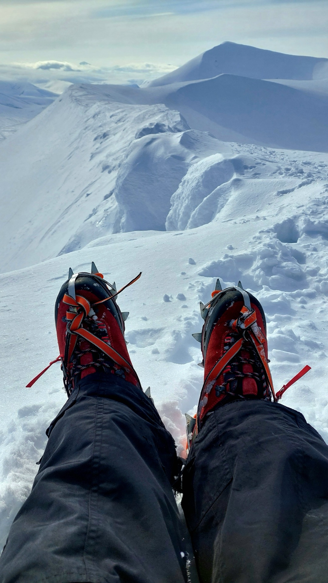 Crampons on a snow ridge with a view across the Svalbard mountains
