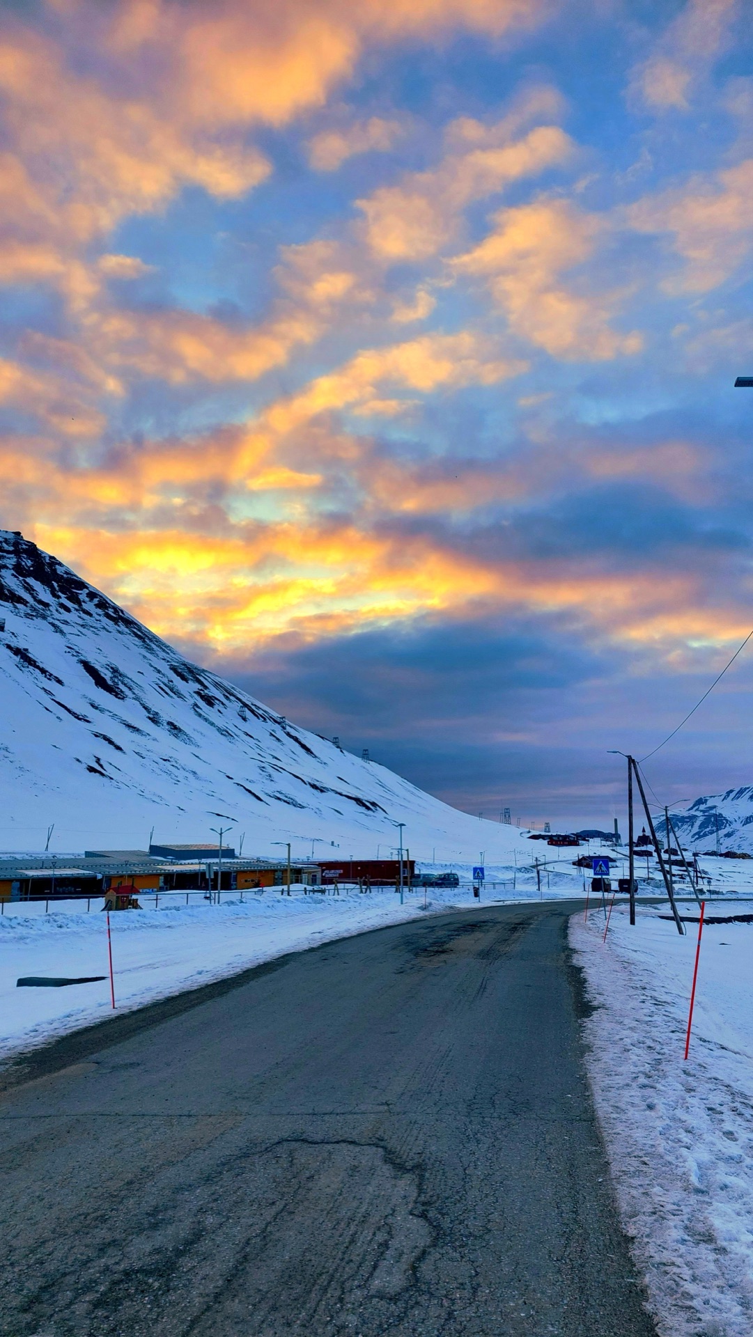 Pomarańczowe i różowe chmury o zachodzie słońca nad drogą do Longyearbyen